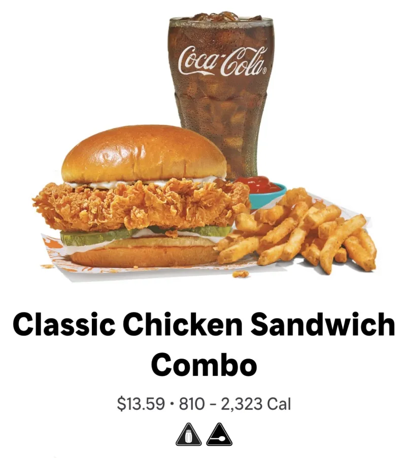 A screenshot of the Popeye's website menu for New York City locations showing calorie information and icons warning of high sodium and added sugar content for their Classic Chicken Sandwich Combo.