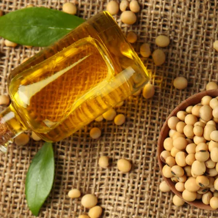 glass bottle full of seed oil on burlap background with seeds sprinkled around