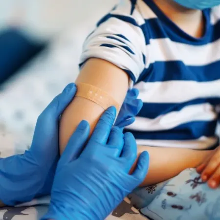 Children's doctor vaccinating little boy against common childhood diseases