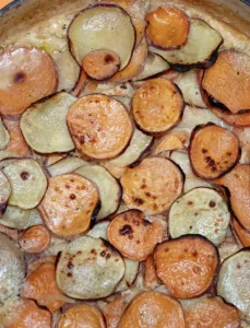 pan filled with scalloped potatoes in a sauce