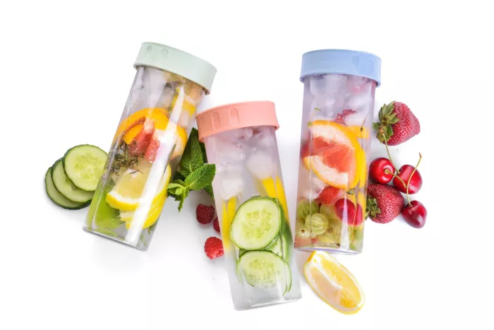 Bottles of mint infused water with berries and citrus