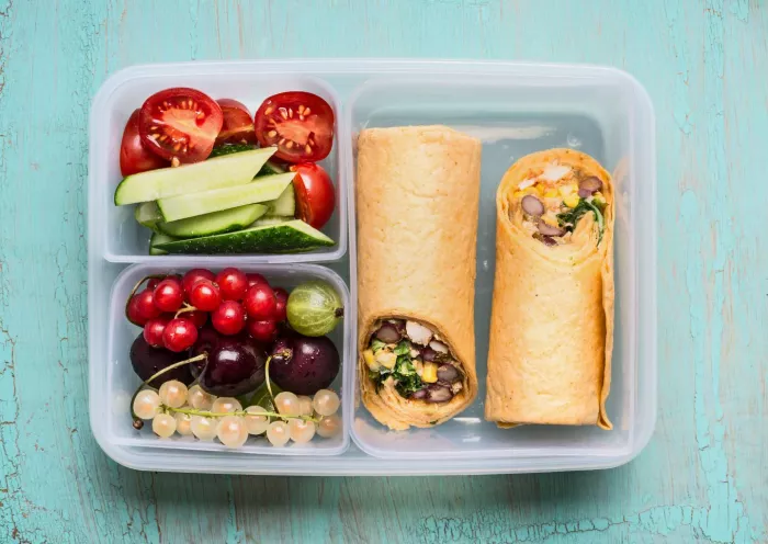 Healthy lunch box with tortilla wraps , fruits and vegetables
