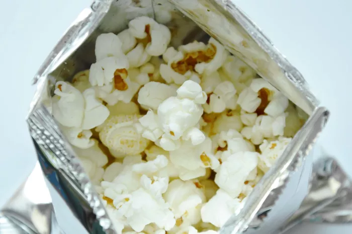 popcorn in metallic packaging on white background