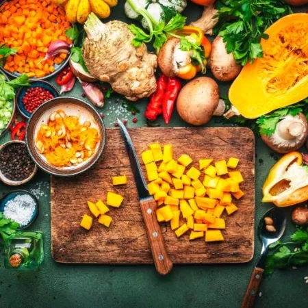 Sliced pumpkin, vegetables, mushrooms, root vegetables, spices, wood cutting board. Thanksgiving Day preparation. Healthy eating, slow food.