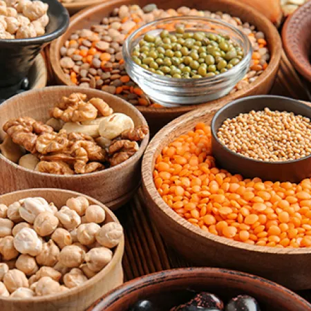 several wooden bowls fille with all different lentils and legumes